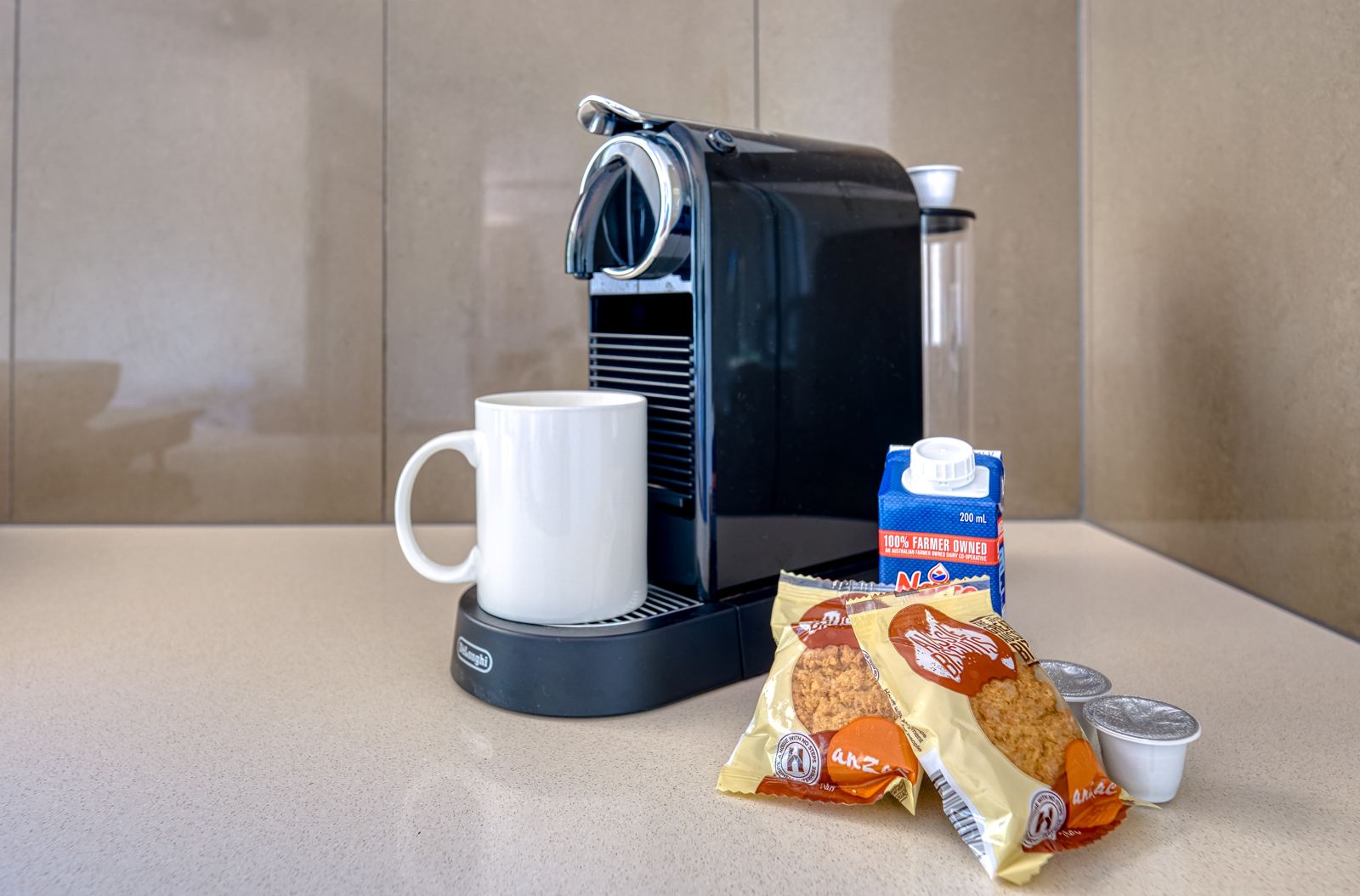 Nespresso machine with coffee pods, milk and Anzac biscuits