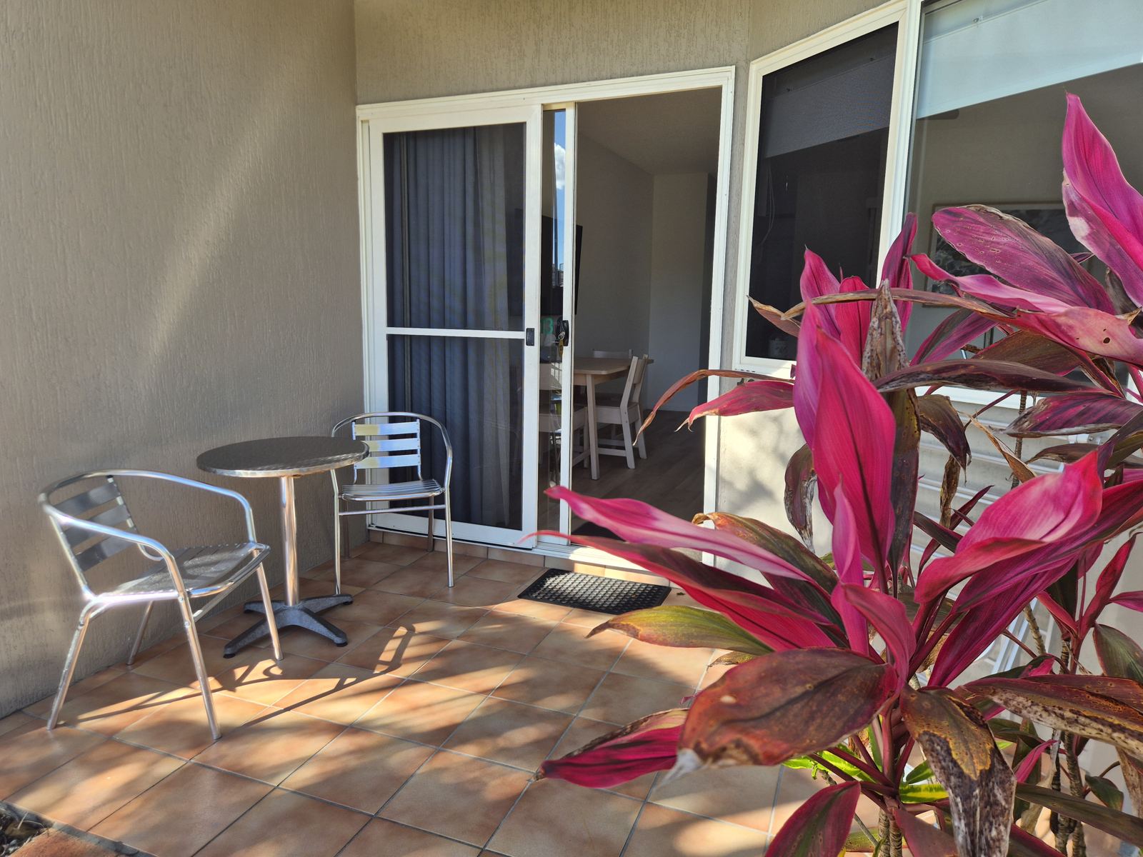 Private tiled courtyard with bistro table and chairs outside the sliding doors