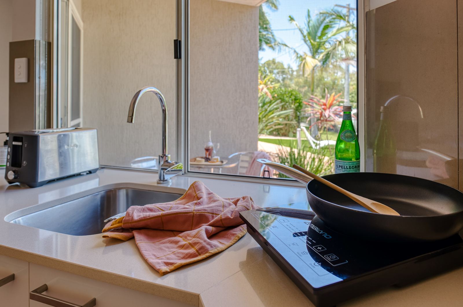 Kitchenette with induction cooktop and toaster, looking out to the garden courtyard