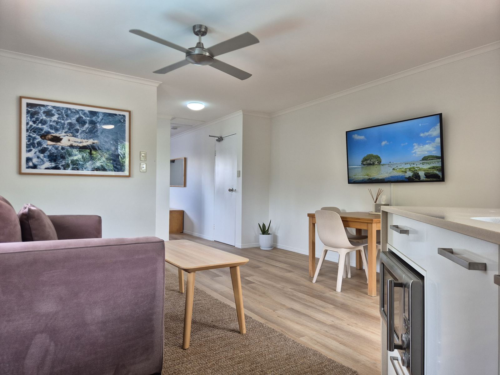 Living area with velvet lounge, coffee table, dining table and Smart TV